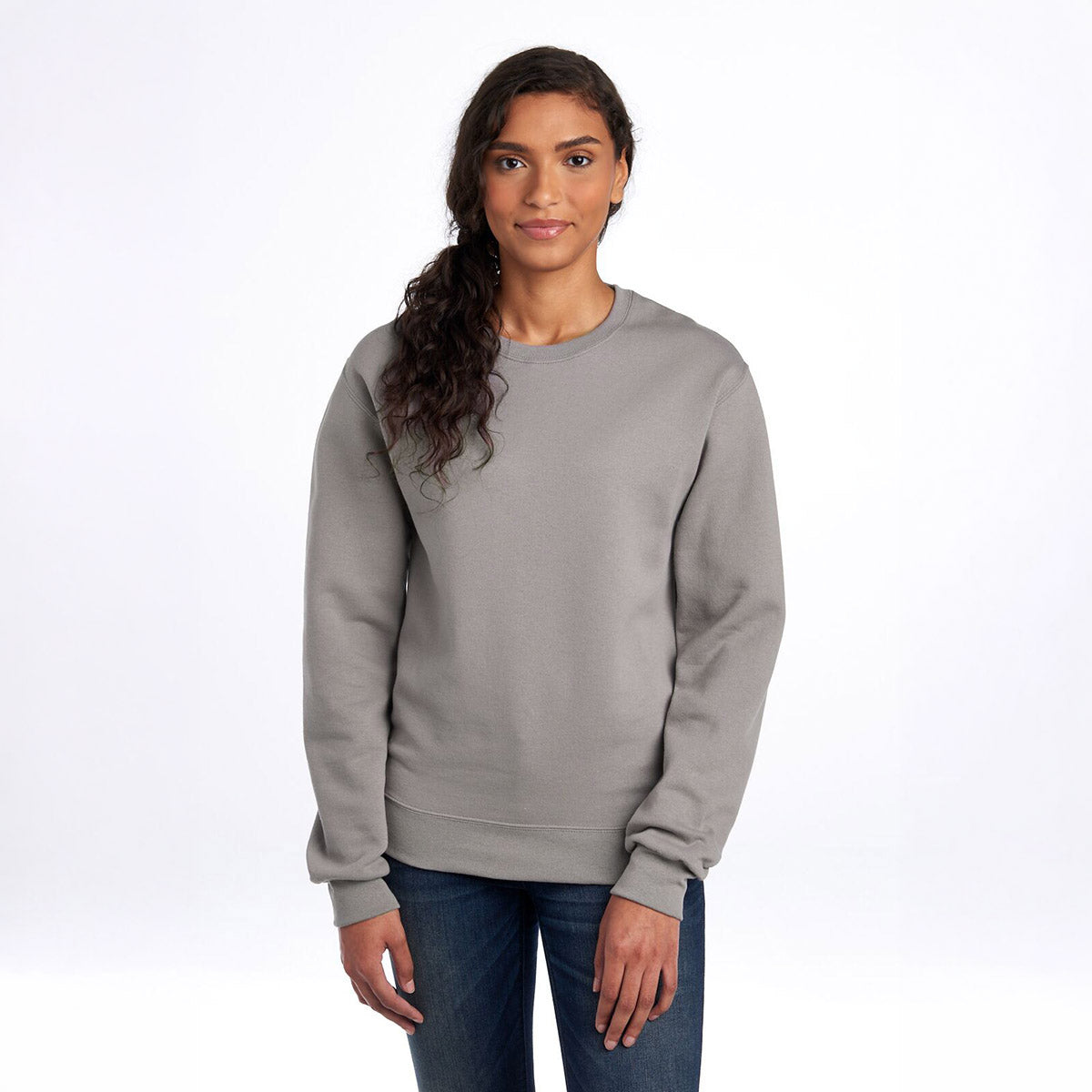 Woman wearing a Rock-colored Jerzees NuBlend® Adult Sweatshirt on a white background.