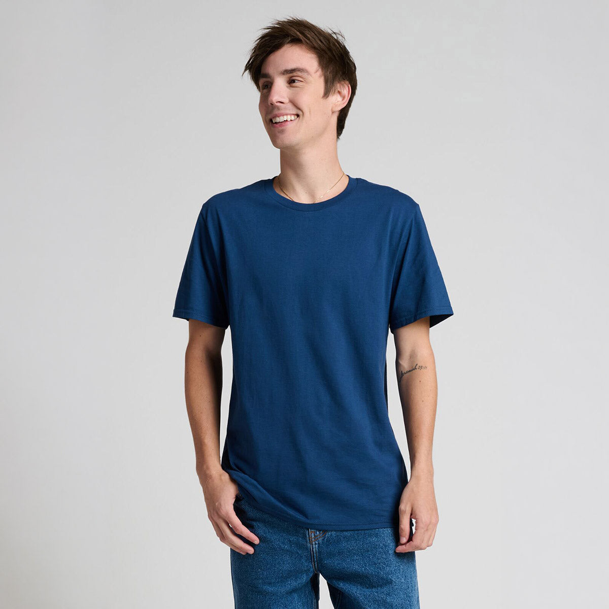 A man smiling while wearing a Jerzees Premium Combed Ring-Spun Cotton Unisex T-Shirt in Washed Navy.