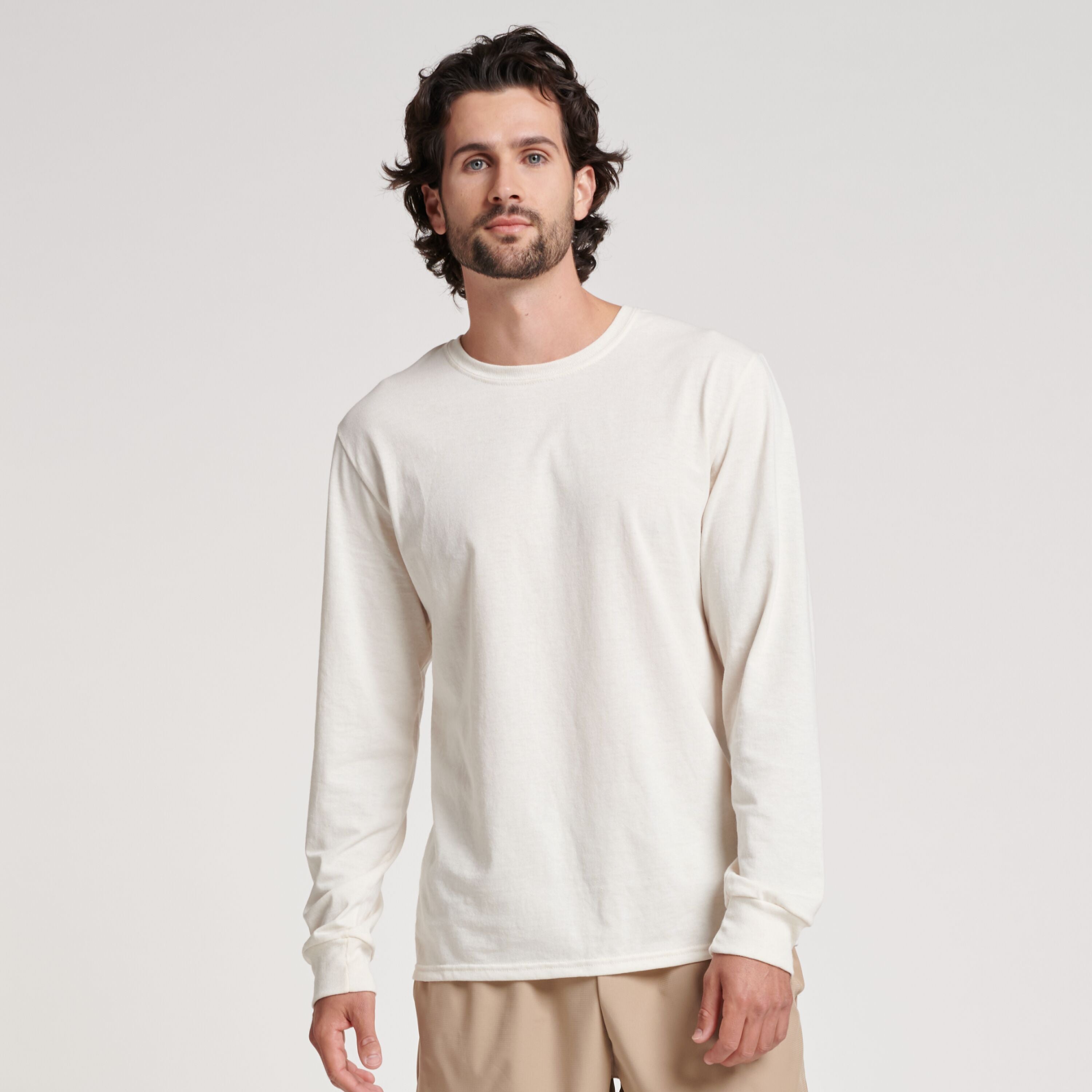 Man wearing a Russell Athletic DRI-POWER CVC Performance Unisex Long-Sleeve T-Shirt in Vintage White.
