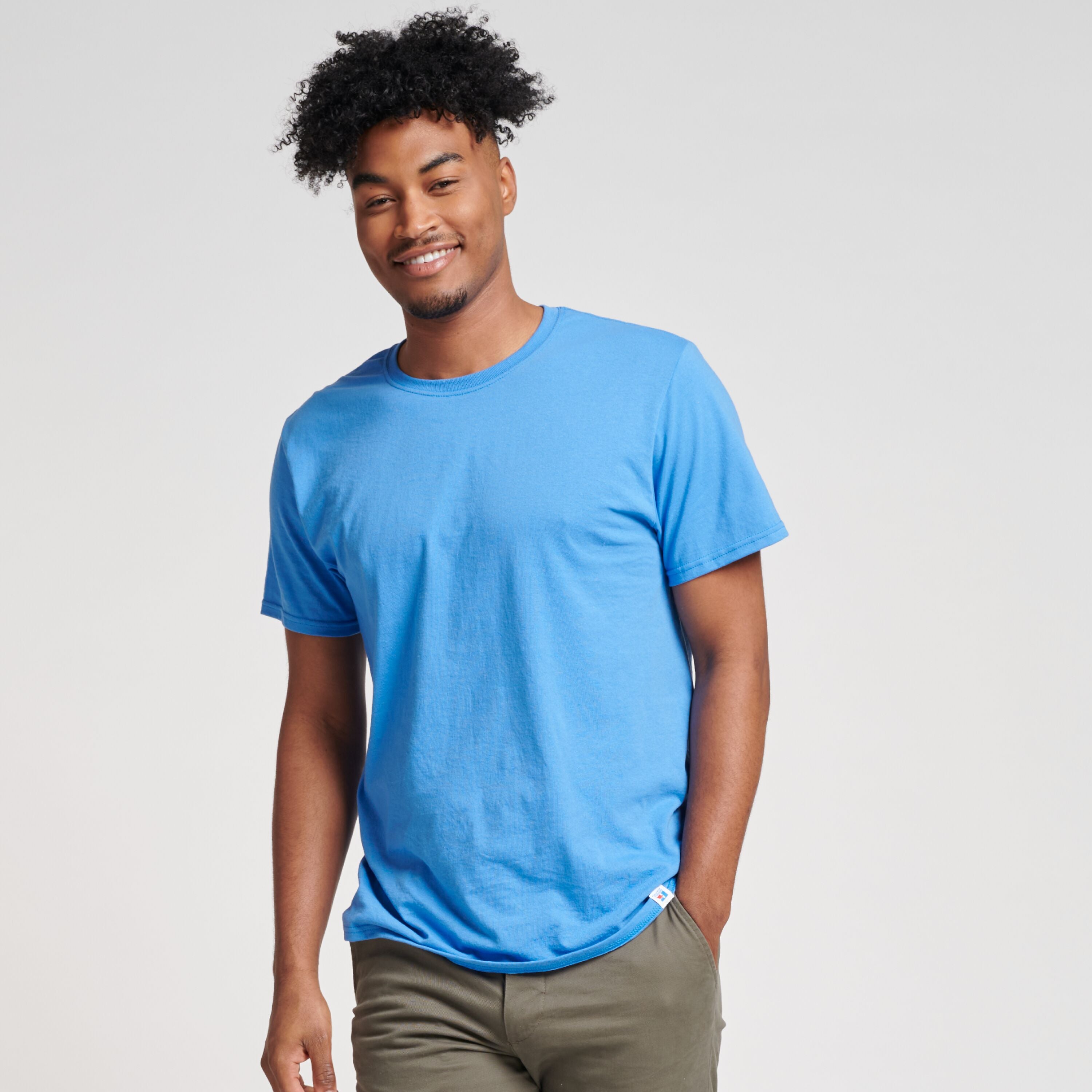 A man wearing a Russell Athletic DRI-POWER CVC Performance Collegiate Blue unisex t-shirt.