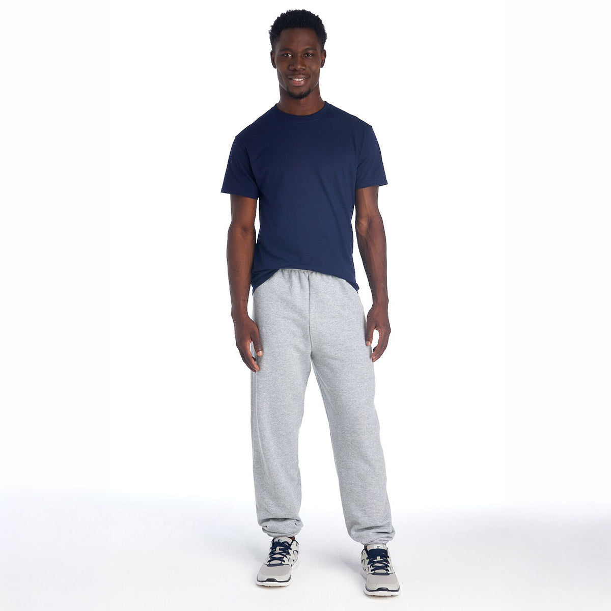 Jerzees NuBlend Adult Sweatpants in black heather worn by a model in a navy t-shirt.