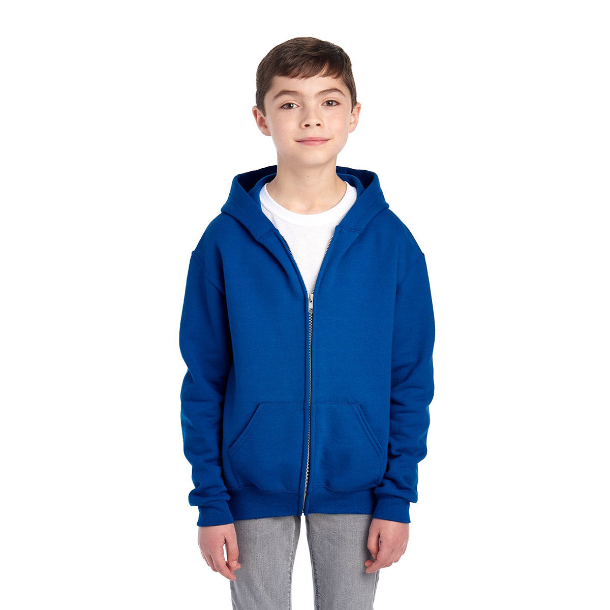 A boy wearing a royal blue Jerzees NuBlend® Youth Full-Zip Hooded Sweatshirt over a white t-shirt.