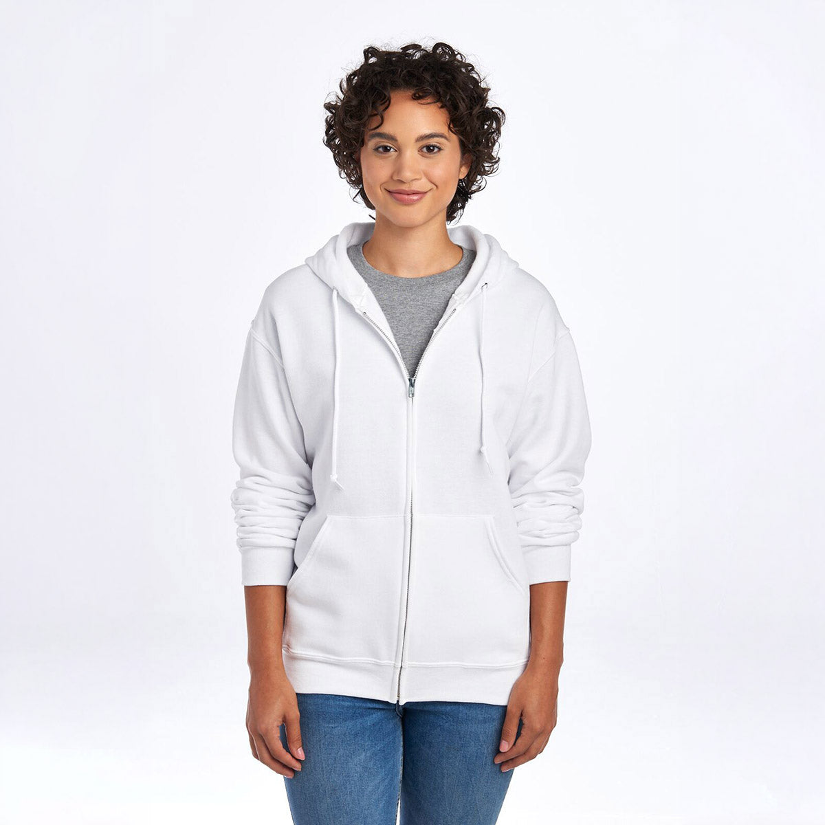 Model wearing a white Jerzees NuBlend unisex full-zip hooded sweatshirt over a grey t-shirt and blue jeans.