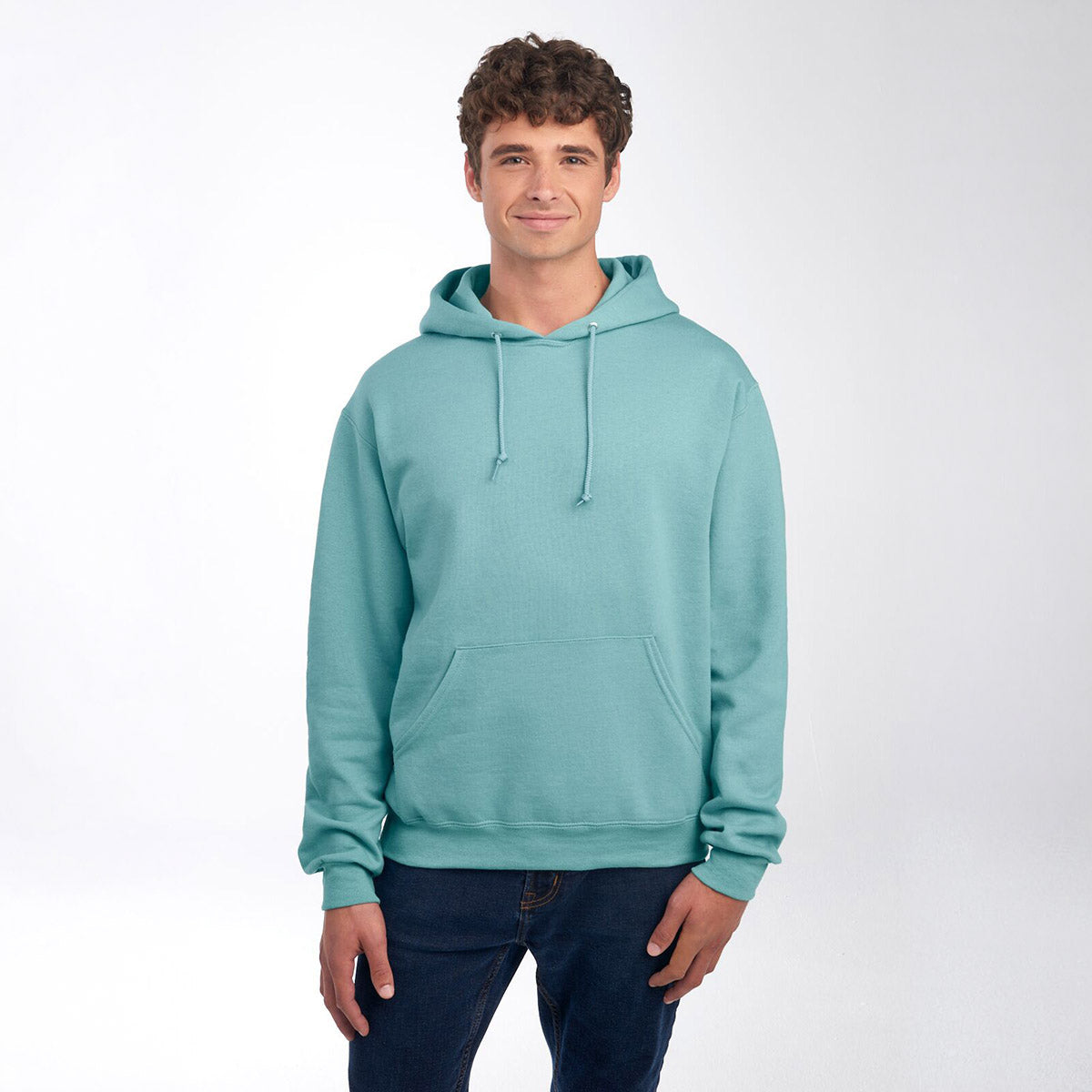 A man wearing a Sage Jerzees NuBlend Unisex Hooded Sweatshirt against a plain white background.