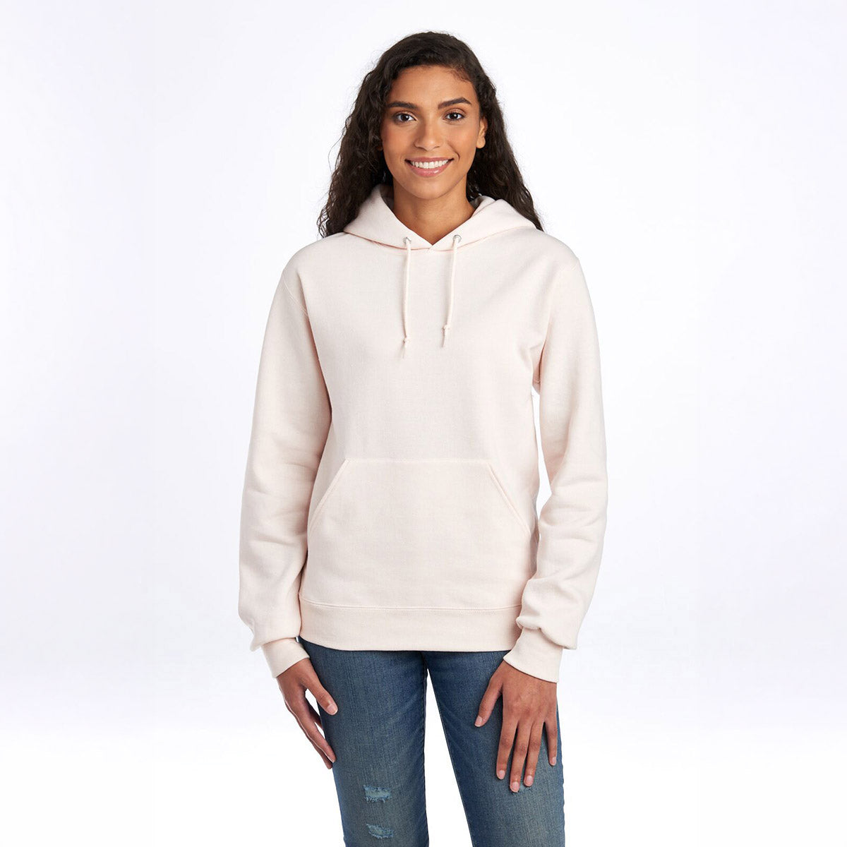 A woman wearing a Sweet Cream Heather Jerzees NuBlend Unisex Hooded Sweatshirt against a white background.