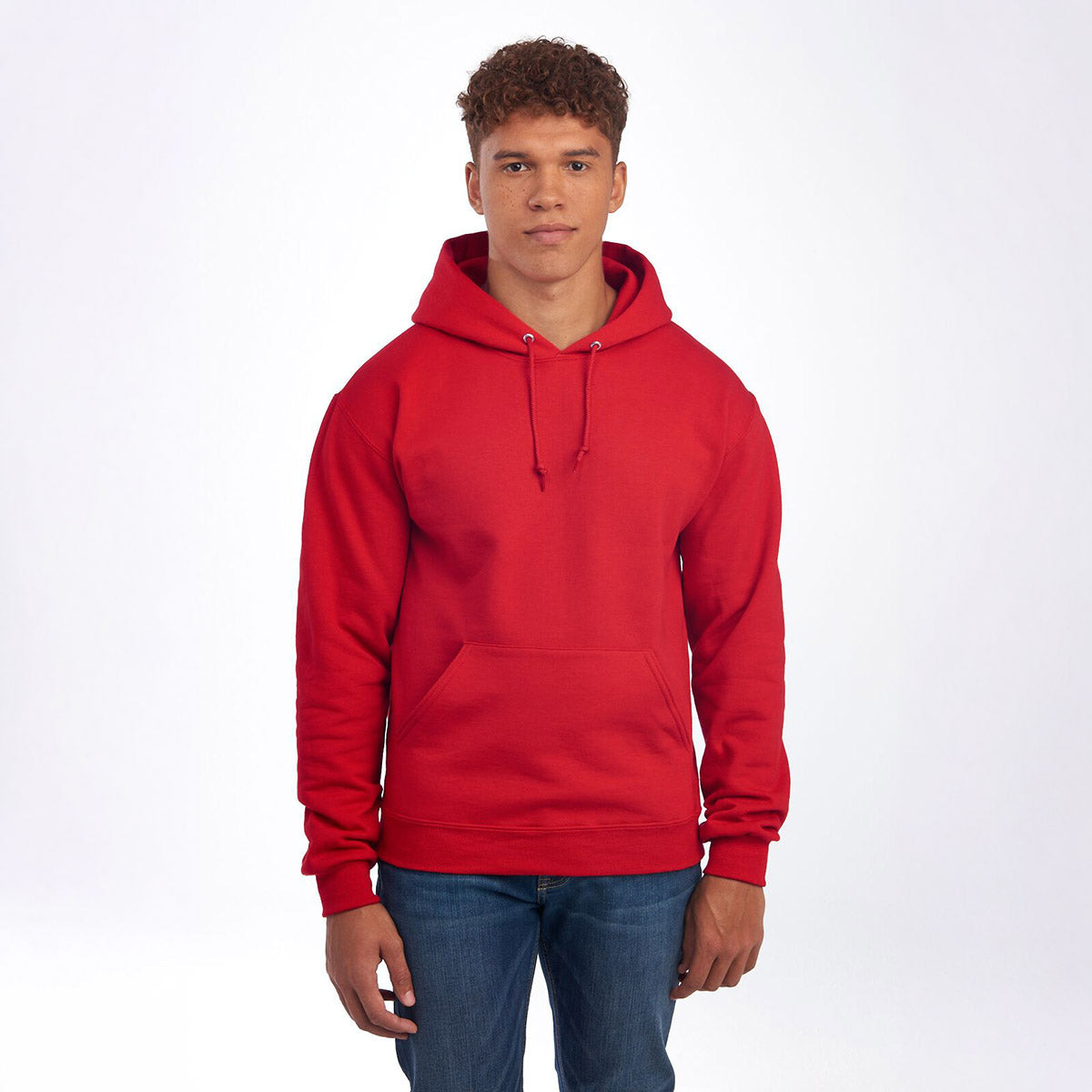 A young man wearing a True Red Jerzees NuBlend Unisex Hooded Sweatshirt against a white background.