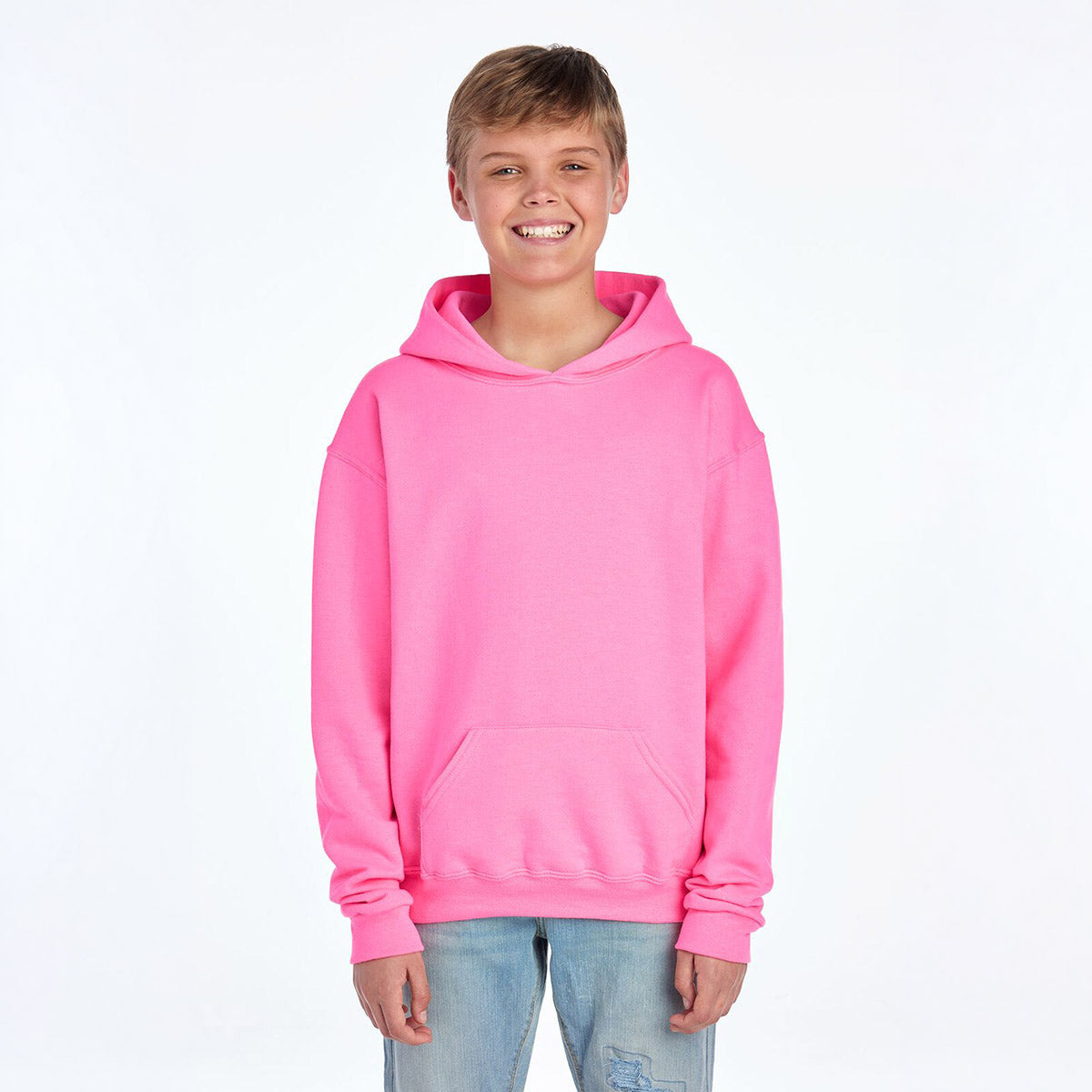 A young boy wearing a Neon Pink Jerzees NuBlend® Youth Hooded Sweatshirt against a plain white background.