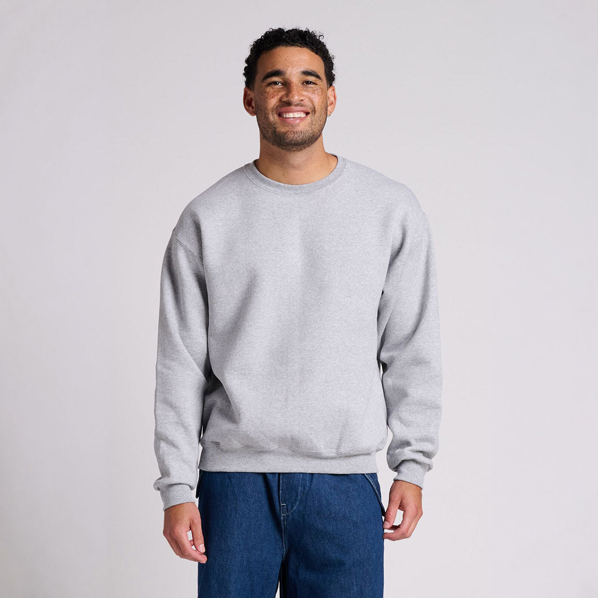 Man wearing a Jerzees Rugged Unisex Sweatshirt in athletic heather.
