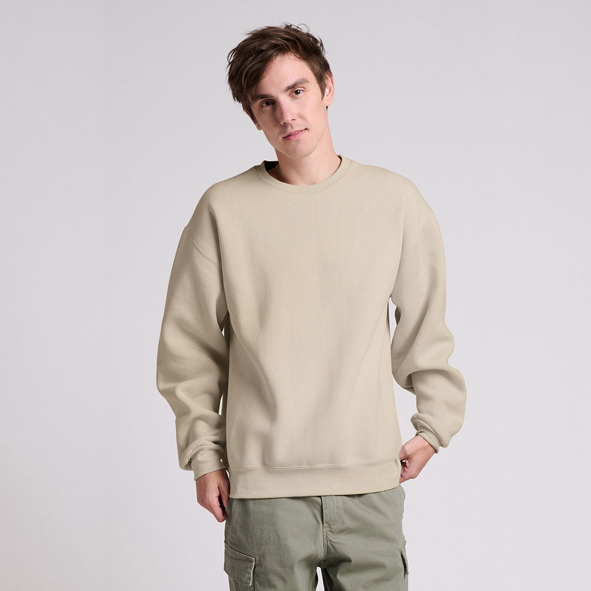Man wearing a Jerzees Rugged unisex sweatshirt in putty color.