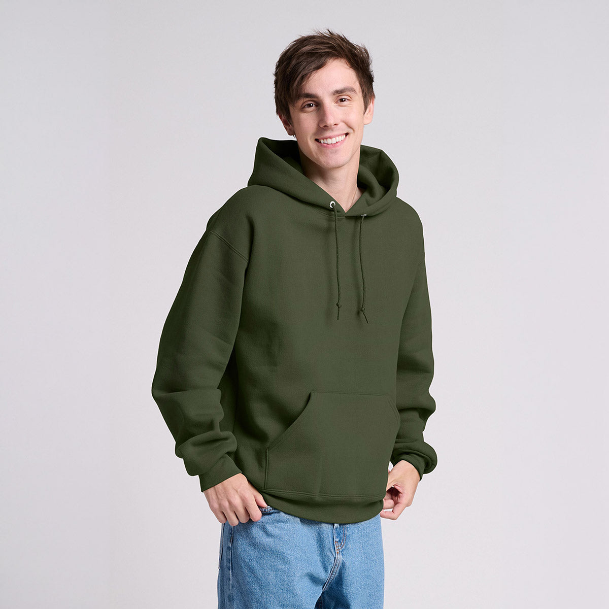 A man wearing a Military Green Jerzees Rugged Unisex Hooded Sweatshirt against a light gray background.
