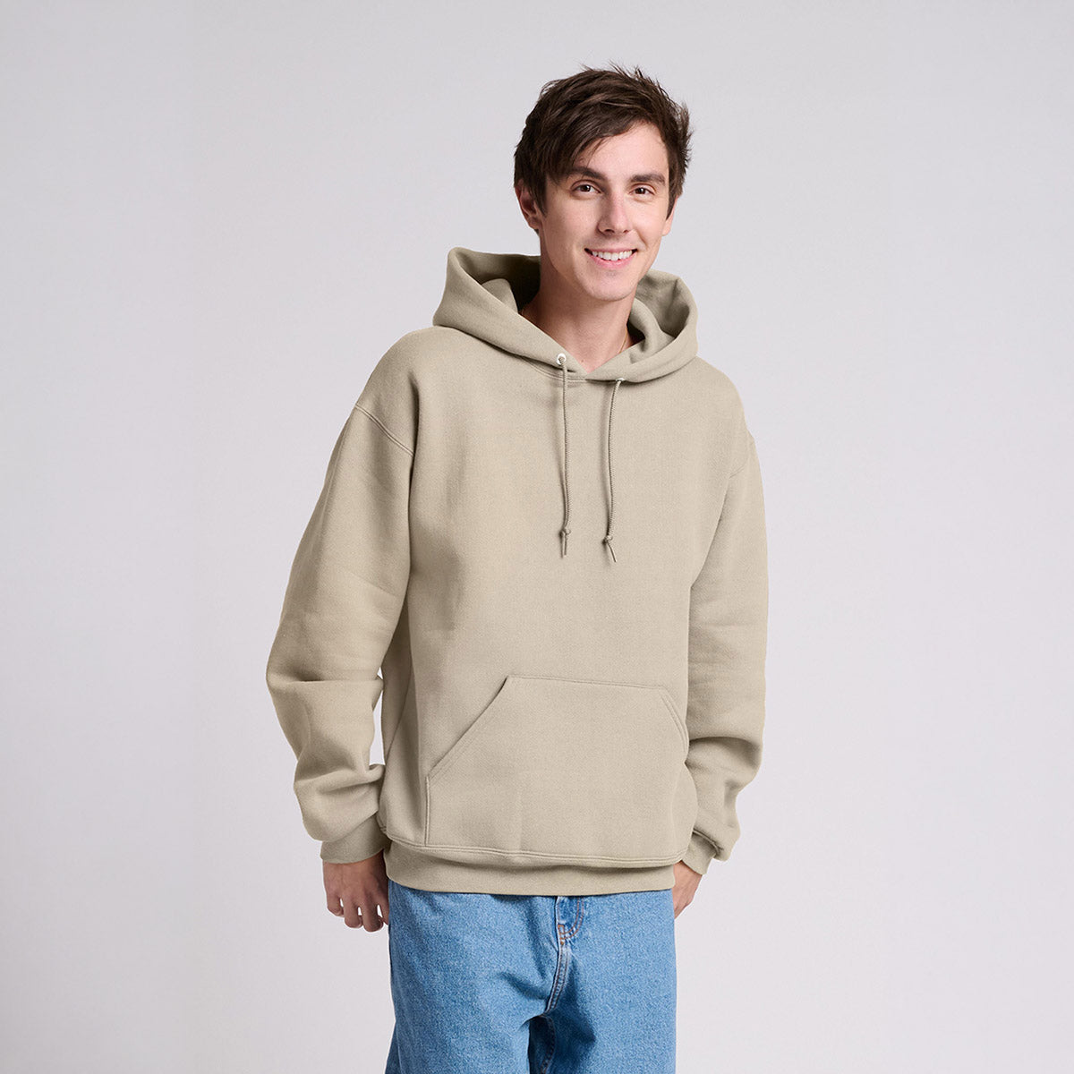 A man wearing a Jerzees Rugged Unisex Hooded Sweatshirt in putty.