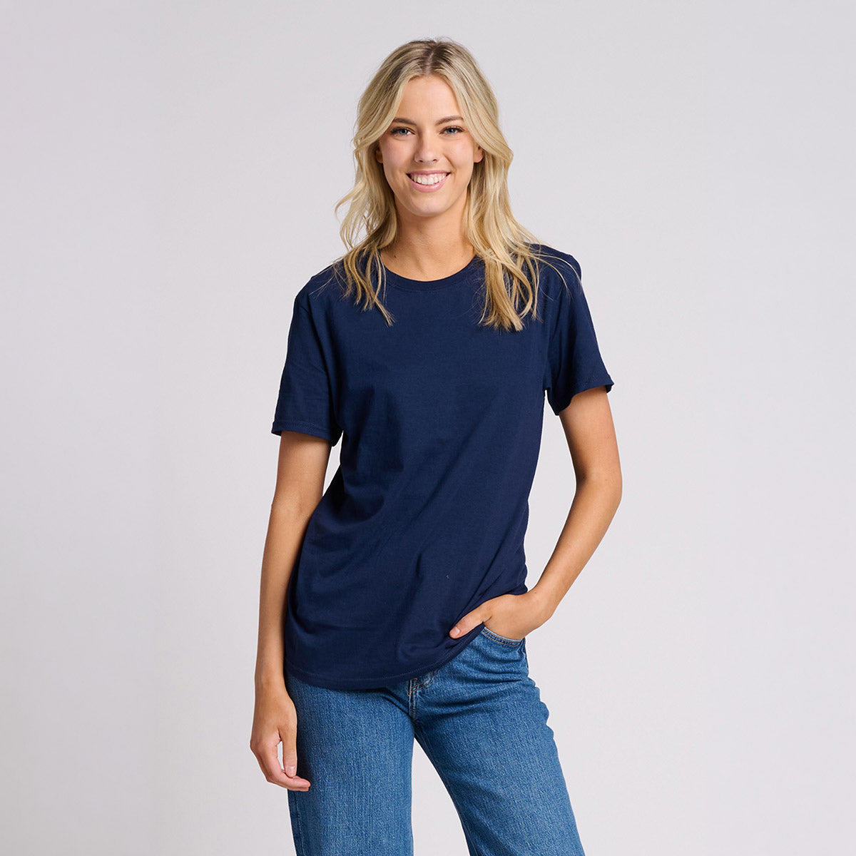 Woman wearing a Jerzees Ultimate Ring-Spun unisex t-shirt in J. Navy paired with blue jeans.