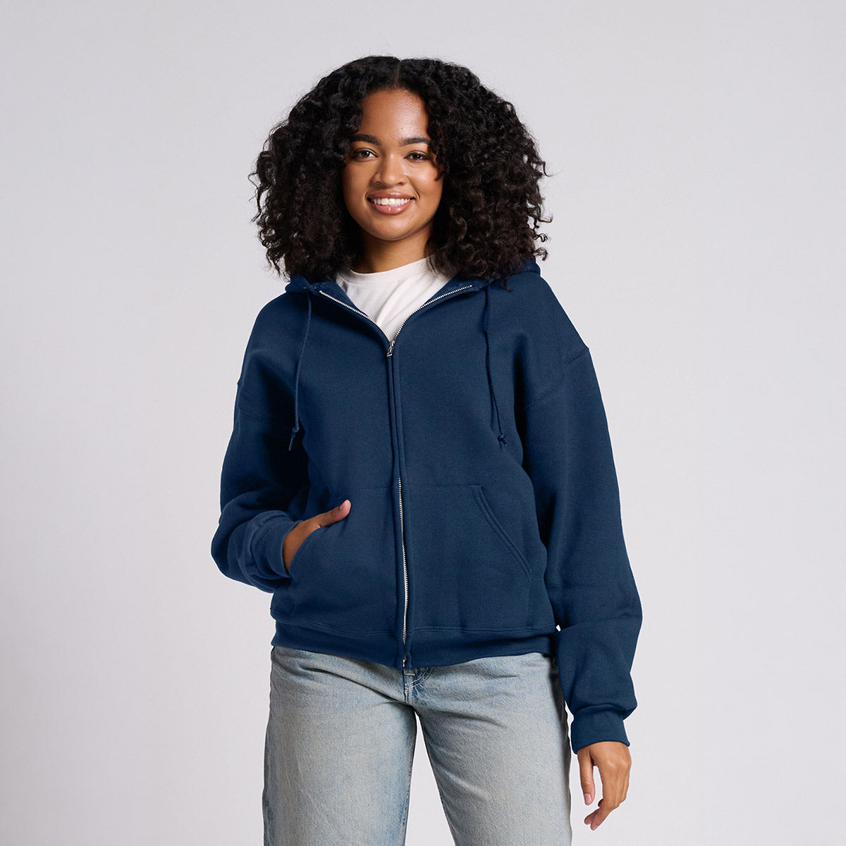 A model wearing a Jerzees Rugged® Unisex Full-Zip Hooded Sweatshirt in Washed Navy.