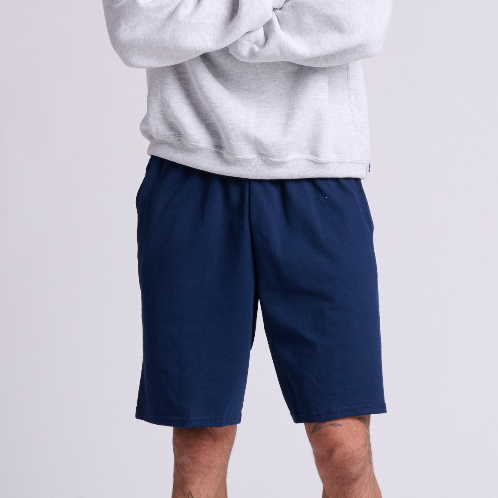Russell Athletic cotton jersey navy sweatshorts with pockets paired with a gray sweatshirt.