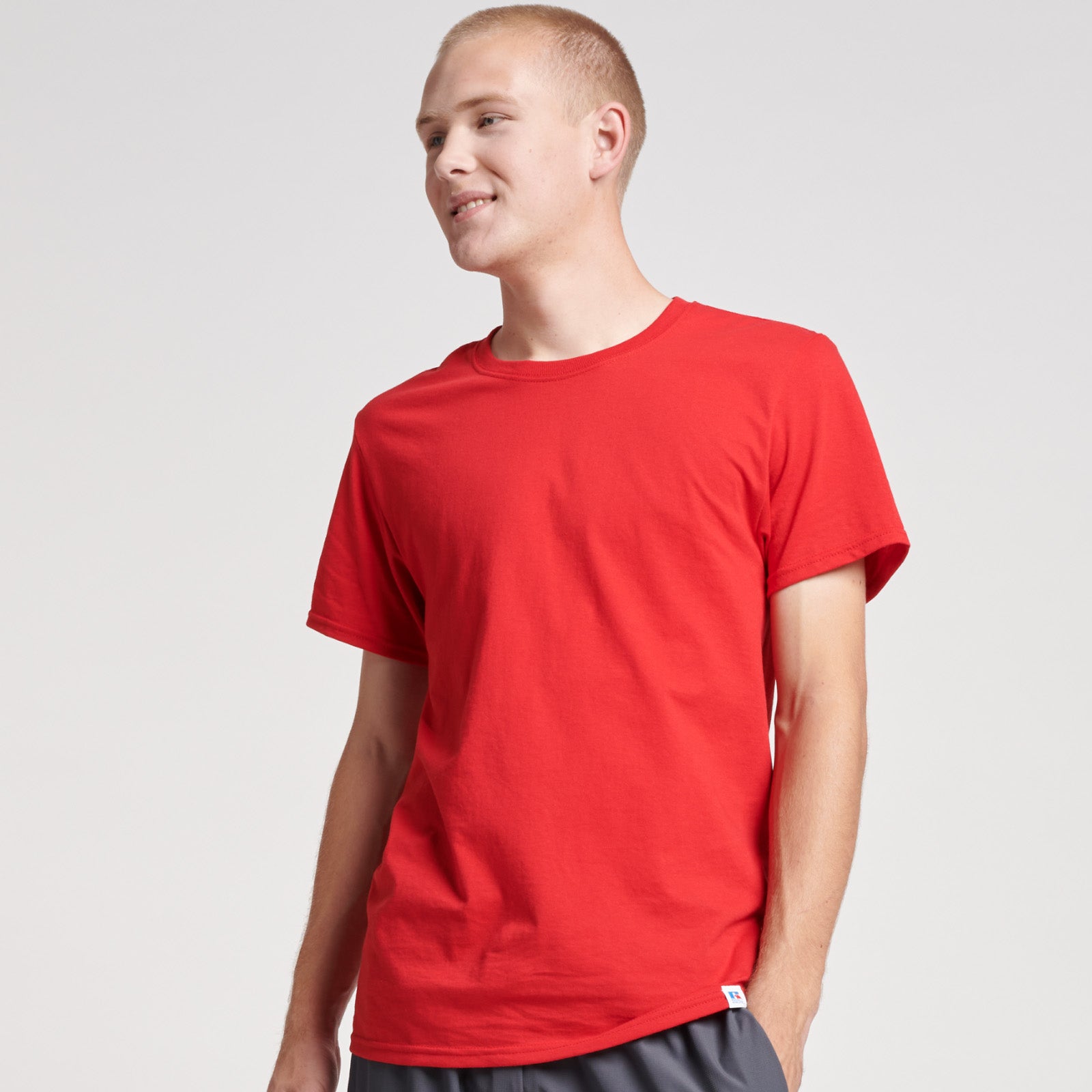 A man wearing a Russell Athletic DRI-POWER CVC Performance unisex T-shirt in True Red.