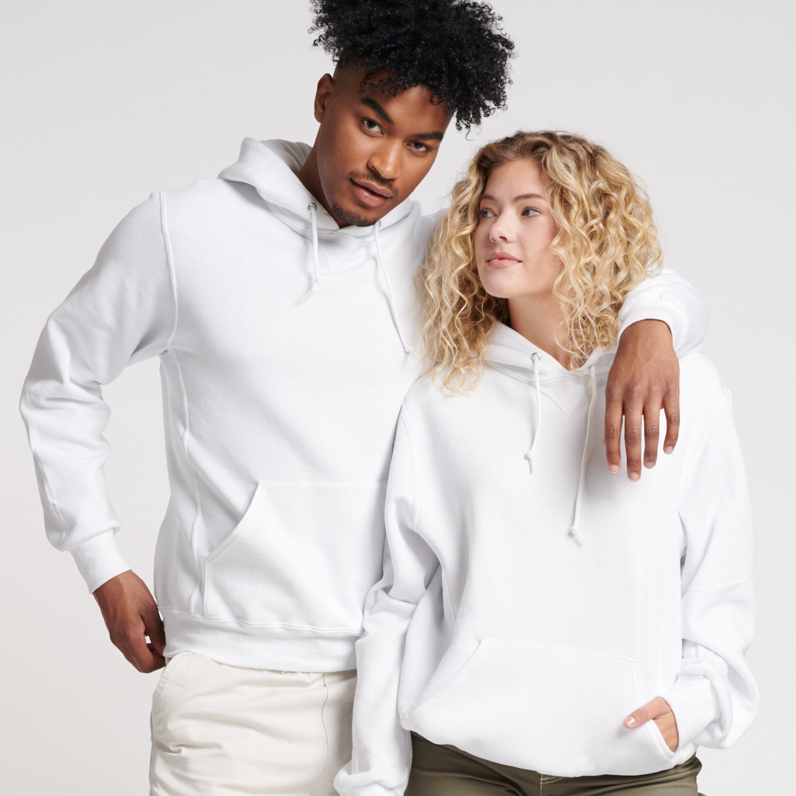 Man and woman wearing white Russell Athletic DRI-POWER Adult Fleece Unisex Hoodies.
