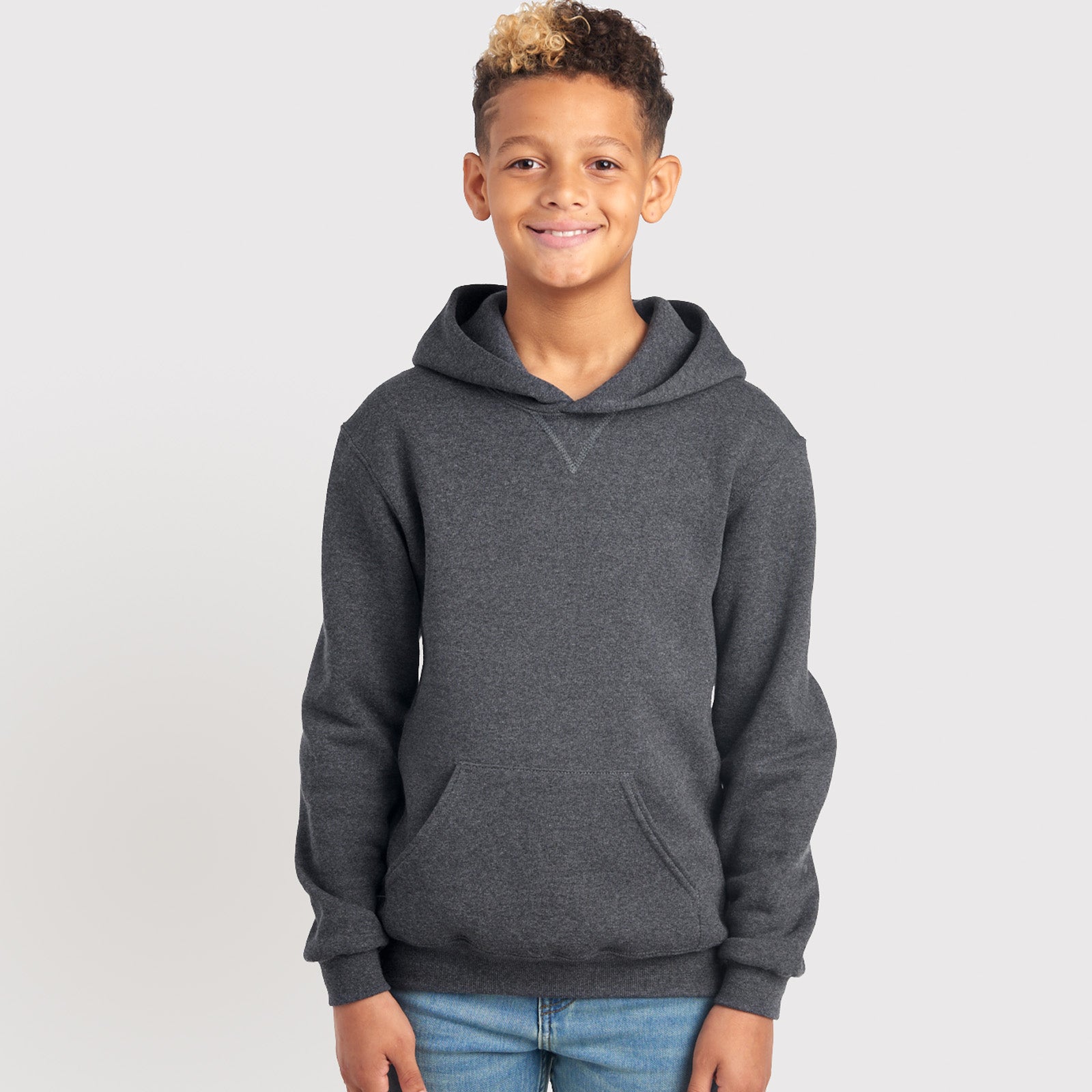 A boy wearing a Black Heather Russell Athletic DRI-POWER Youth Fleece Pullover Hoodie.