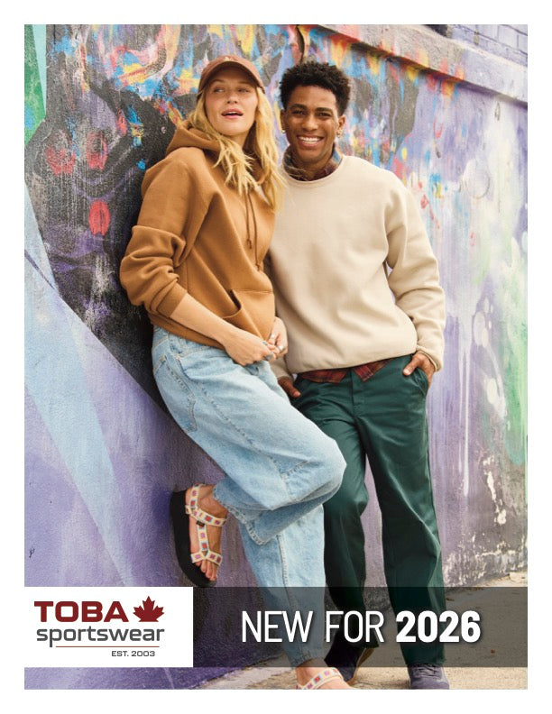 Toba Sportswear lifestyle shot featuring a woman in a brown hoodie and a man in a beige sweatshirt posing against graffiti.