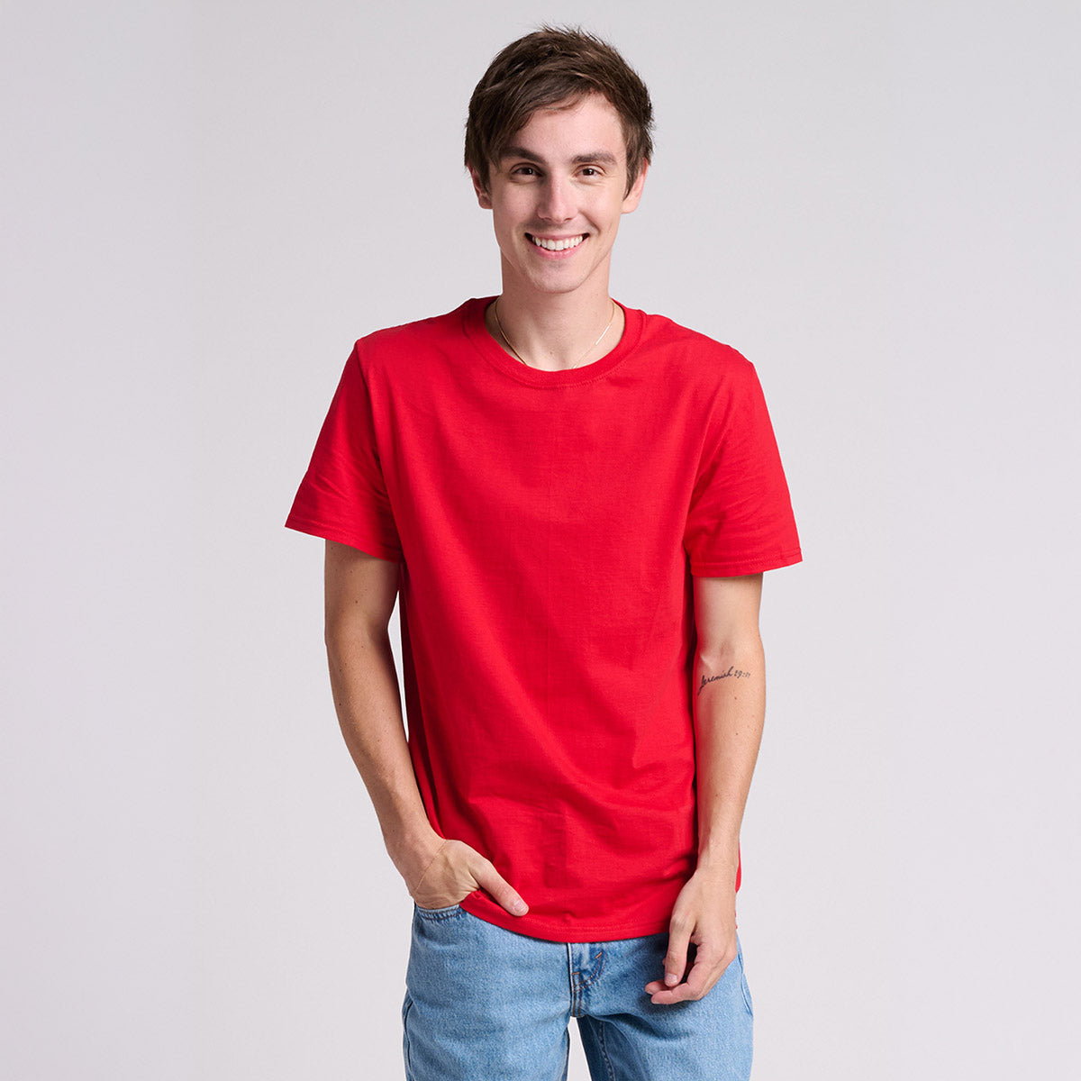 Young man wearing a Jerzees Ultimate Ring-Spun Unisex T-Shirt in True Red.